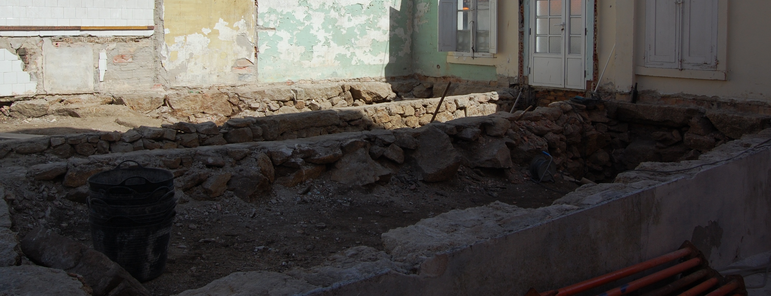 Foto donde se observa una antigua cimentación mediante muros de piedra.