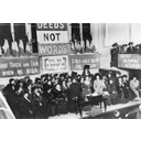 A suffragette meeting in Manchester, England, circa 1908, with Emmeline Pankhurst stand in the center of the platform and the suffragette´s moto “ Deeds, not words”