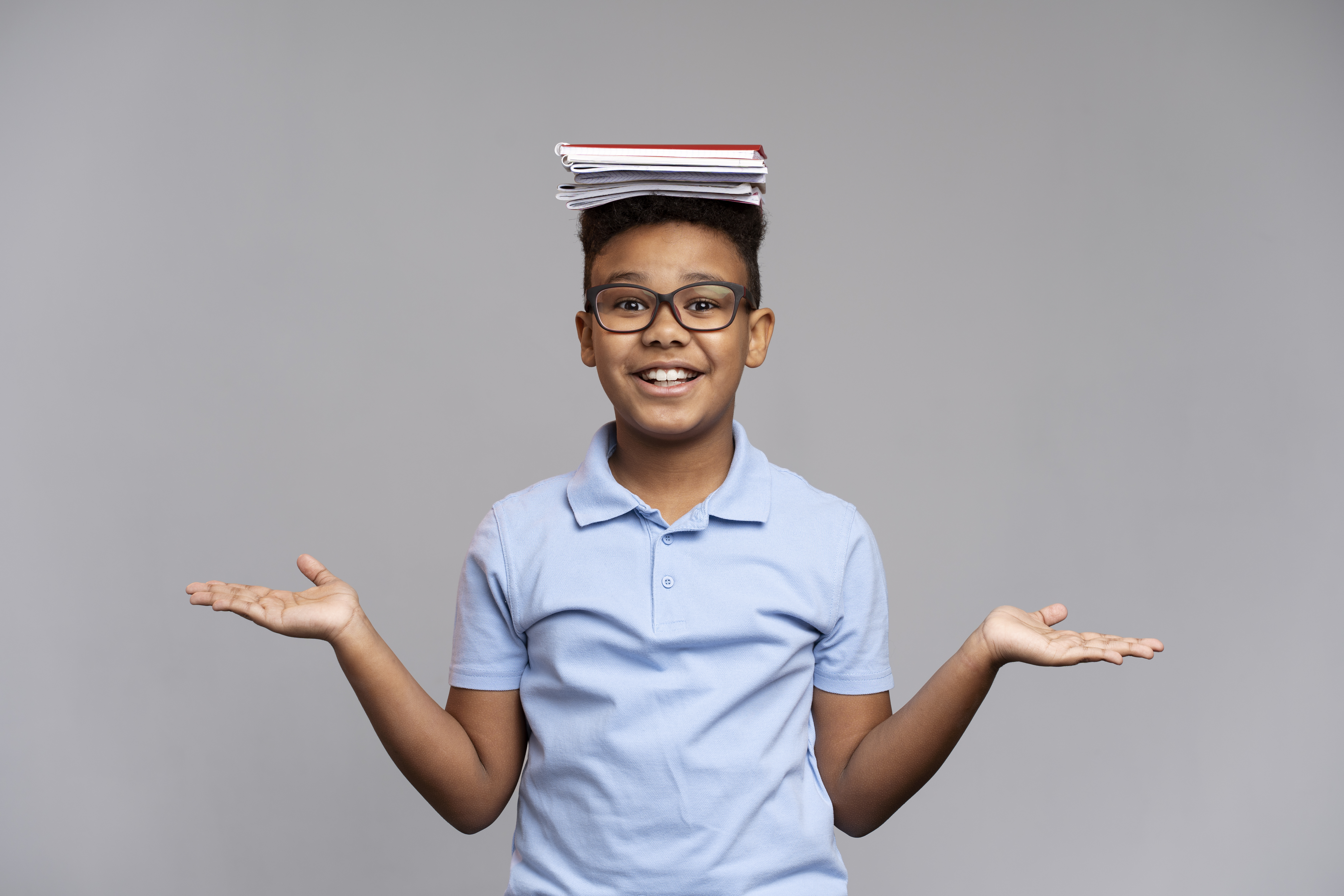 Boy with notebooks on his head