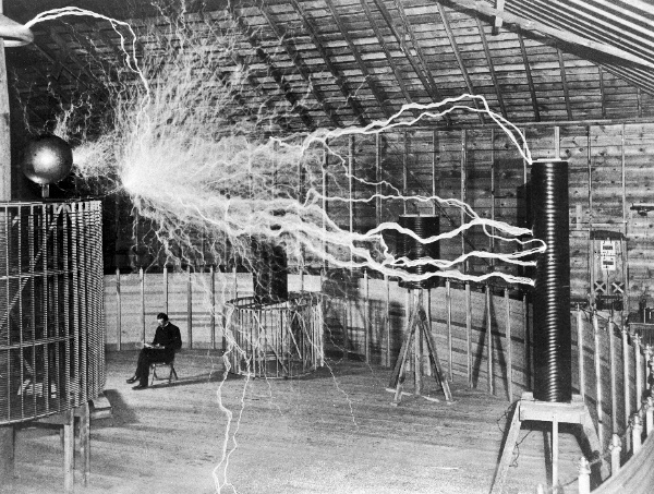 En la imagen puede verse la imagen de Nikola Tesla en su laboratorio con una bobina emitiendo rayos