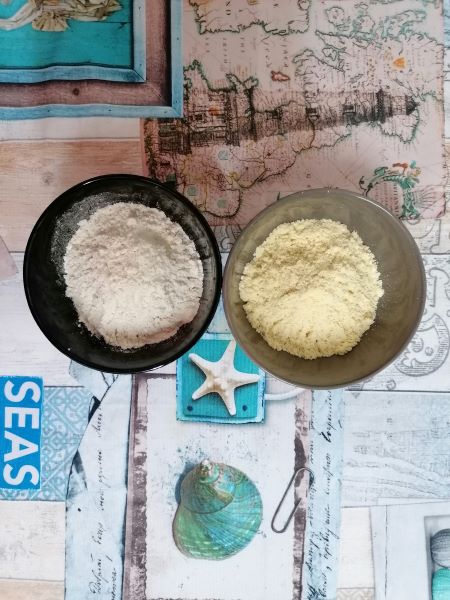 Cuencos con harina de trigo y de maiz sobre un mantel con motivos del ma Cuencos con harina de trigo y de maiz sobre un mantel con motivos del mar