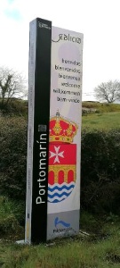 Panel de bienvenida a Portomarín con el escudo del ayuntamiento