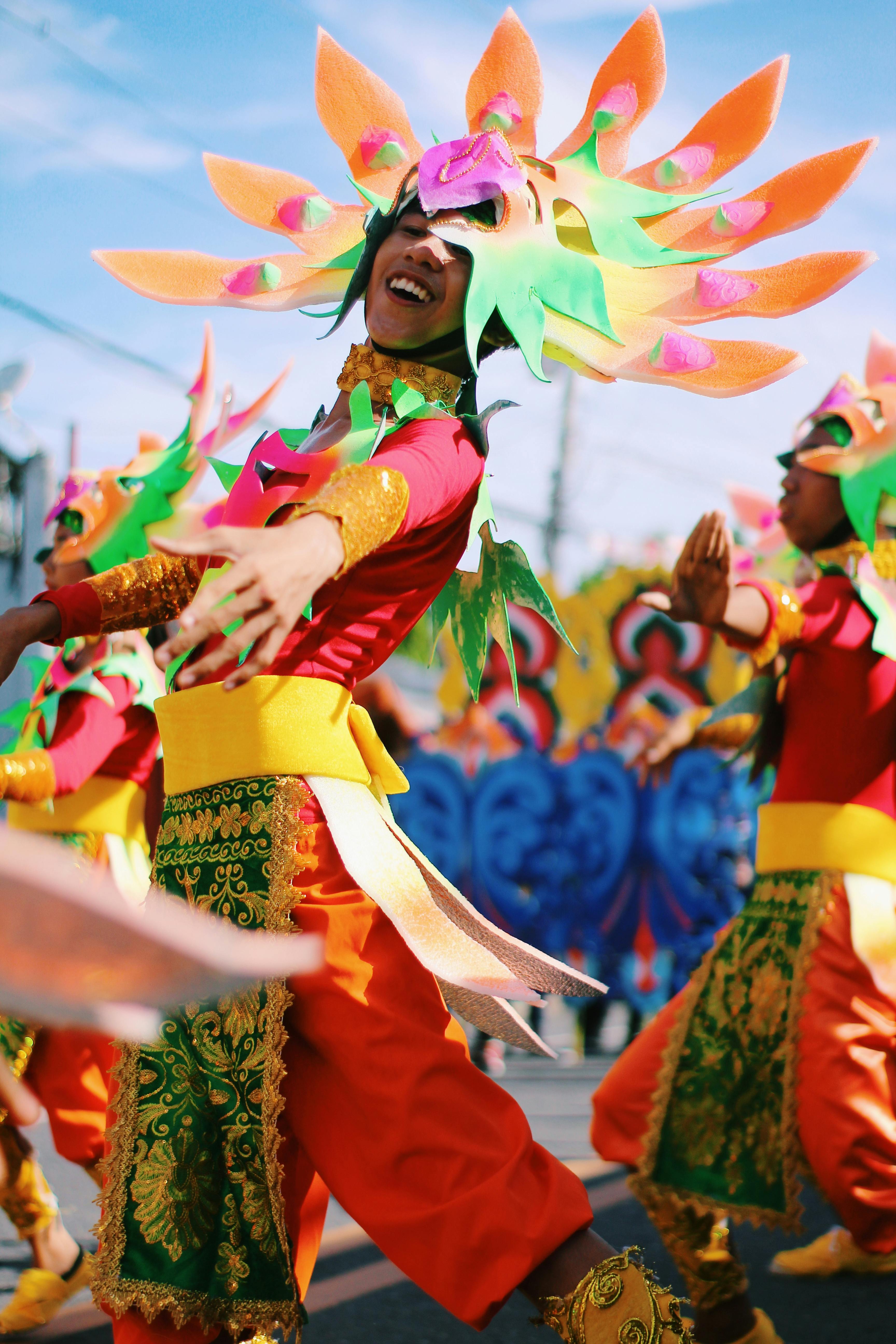 Fotografía que representa unha persoa vestida con moitas cores coma un traxe tradicional para un baile.