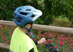 Conduce seguro Foto dun neno cun casco, chaleco e bicicleta