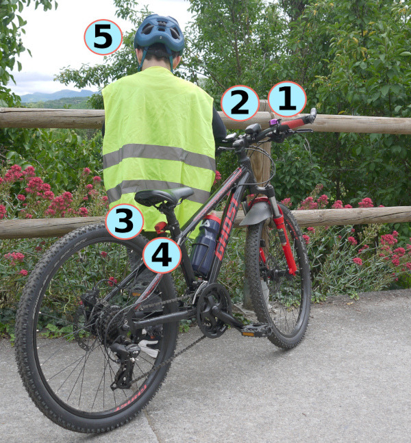 Fotografía dunha bicicleta con varios elementos de seguridade sinalados.