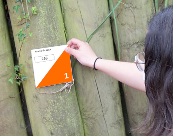 Unha nena coloca unha baliza de madeira nun camiño