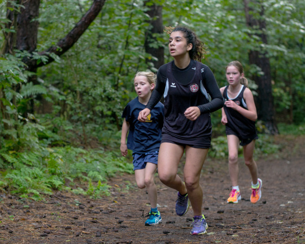Fotografía dunha carreira no medio natural con tres persoas que corren