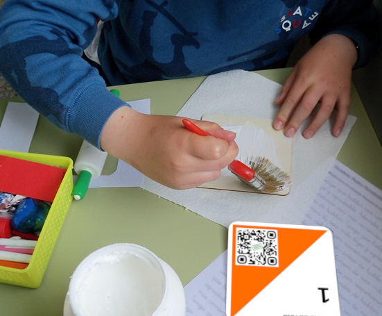 Pegamento para a baliza Un neno pon pegamento nunha baliza de papel