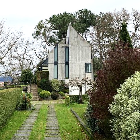 Casa de estilo moderno con jardín y entrada para coches. 
