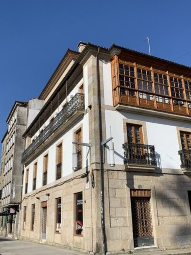 Casa de piedra reformada con paredes blancas y ventanas de madera.