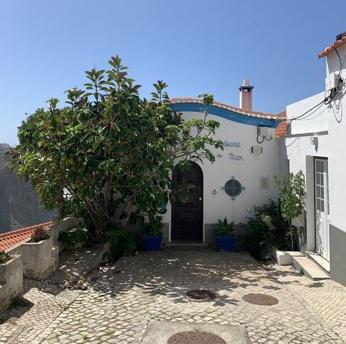 Pequeña casa de pared blanca y puerta de madera.