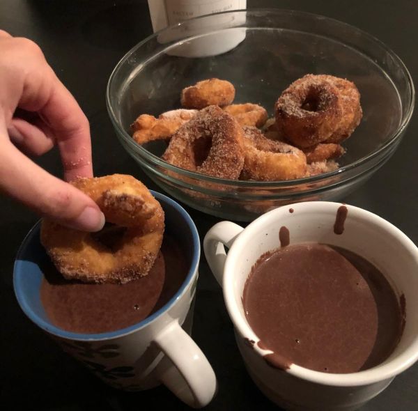 Cuenco con rosquillas y una mojada en chocolate.