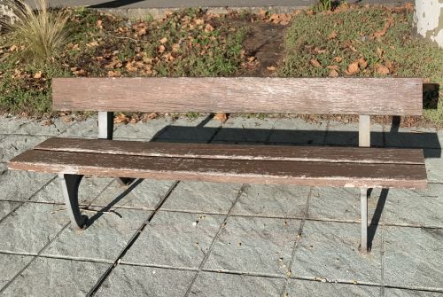 Banco de madera con un listón de madera en el respaldo y dos listones en el asiento.