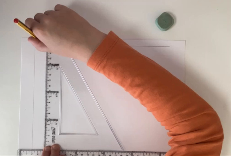 Fotografía que amosa o trazado de liñas paralelas cunha regra e un escuadro