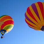 Dous globos aerostáticos de cores voan durante un festival 