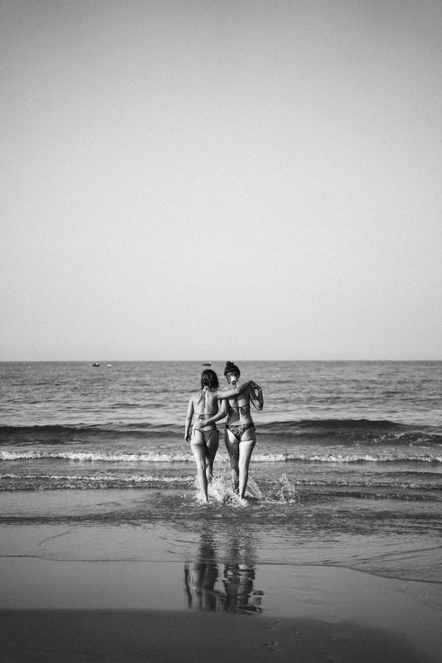 Dos mujeres abrazadas entrando en el mar