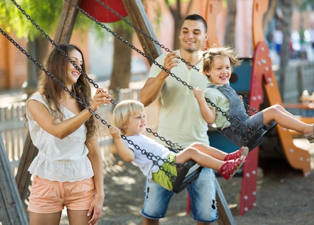 Familias en columpios en el parque
