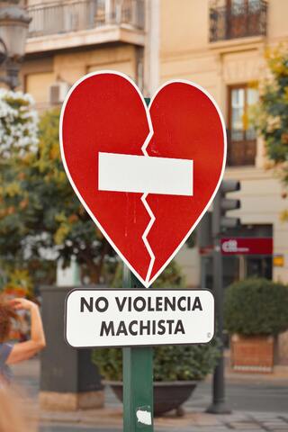 Señal de stop en forma de corazon con cartel de No violencia machista