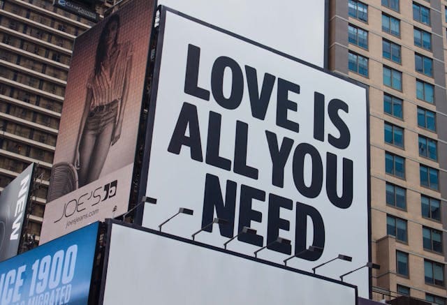Cartel publicitario con anuncio de Love is all you need