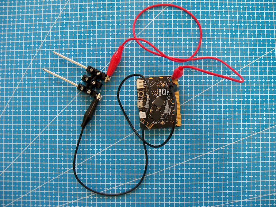 Cravos conectados aos terminais 0 e 1 dunha placa Micro:bit