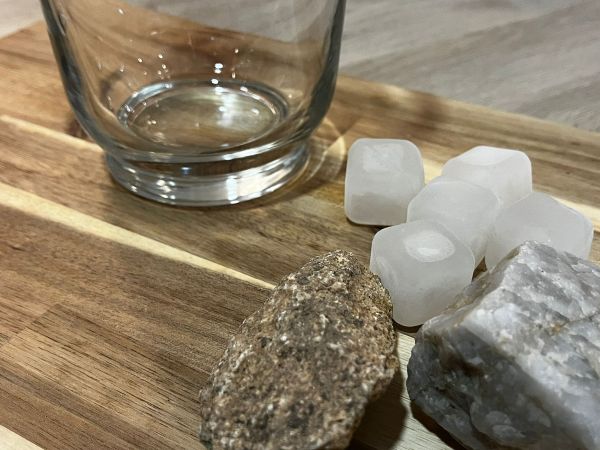 Fotografía pedras, cubos de xeo e un recipiente de vidro.