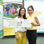 Fotografía de dúas mulleres posando diante duns paneis informativos.