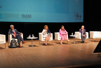 Fotografía dun congreso científico onde catro persoas están sentadas falando