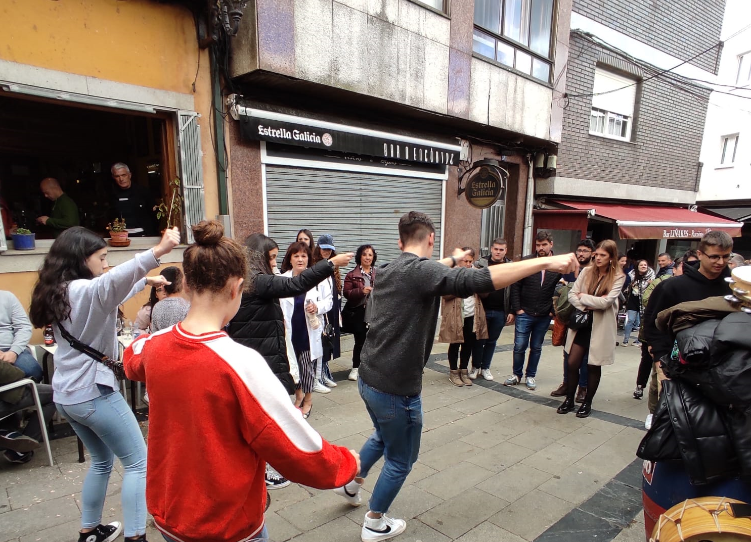 Fotografía de varias persoas bailando nunha foliada informal. é informal porque é improvisada. As persoas están vestidas con roupa que usan no seu día a día
