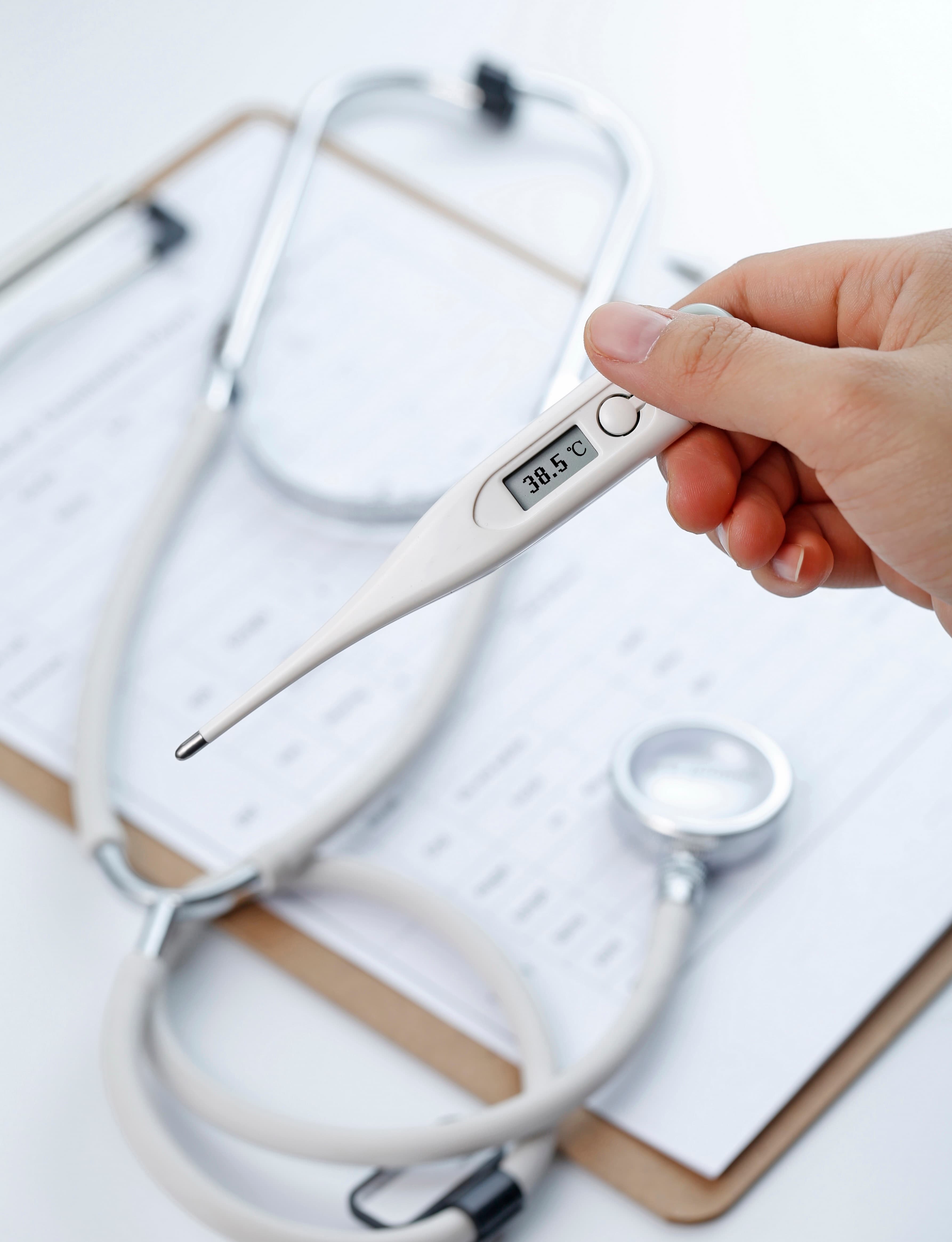 Imaxe dun termómetro, un estetoscopio e un informe médico.