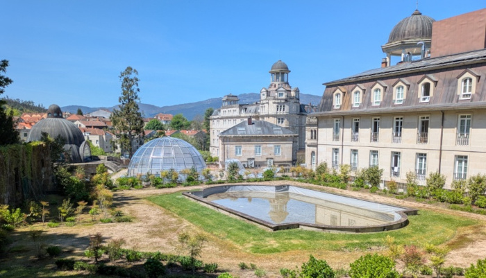 Vista de piscina, fuente y hotel