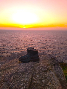 Bota de peregrino con fondo de puesta de sol.