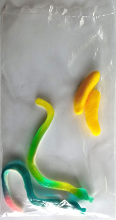 Bolsa de plástico con dos gominolas con forma de serpiente y dos con forma de plátano