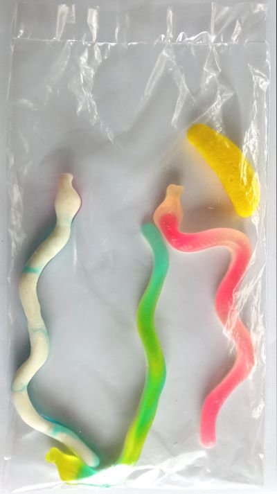 Bolsa de plástico con tres gominolas con forma de serpiente y una con forma de plátano
