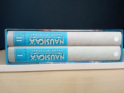 Lote de libros 3 (cREAgal) Volúmenes I y II del cómic NAUSIKAapilados sobre una mesa