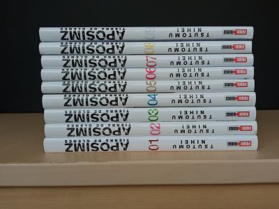 Lote de libros 6 (cREAgal) Volúmenes 1-9 del cómic APOSIMZ apilados sobre una mesa