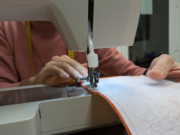 Hombre utilizando máquina de coser. 
