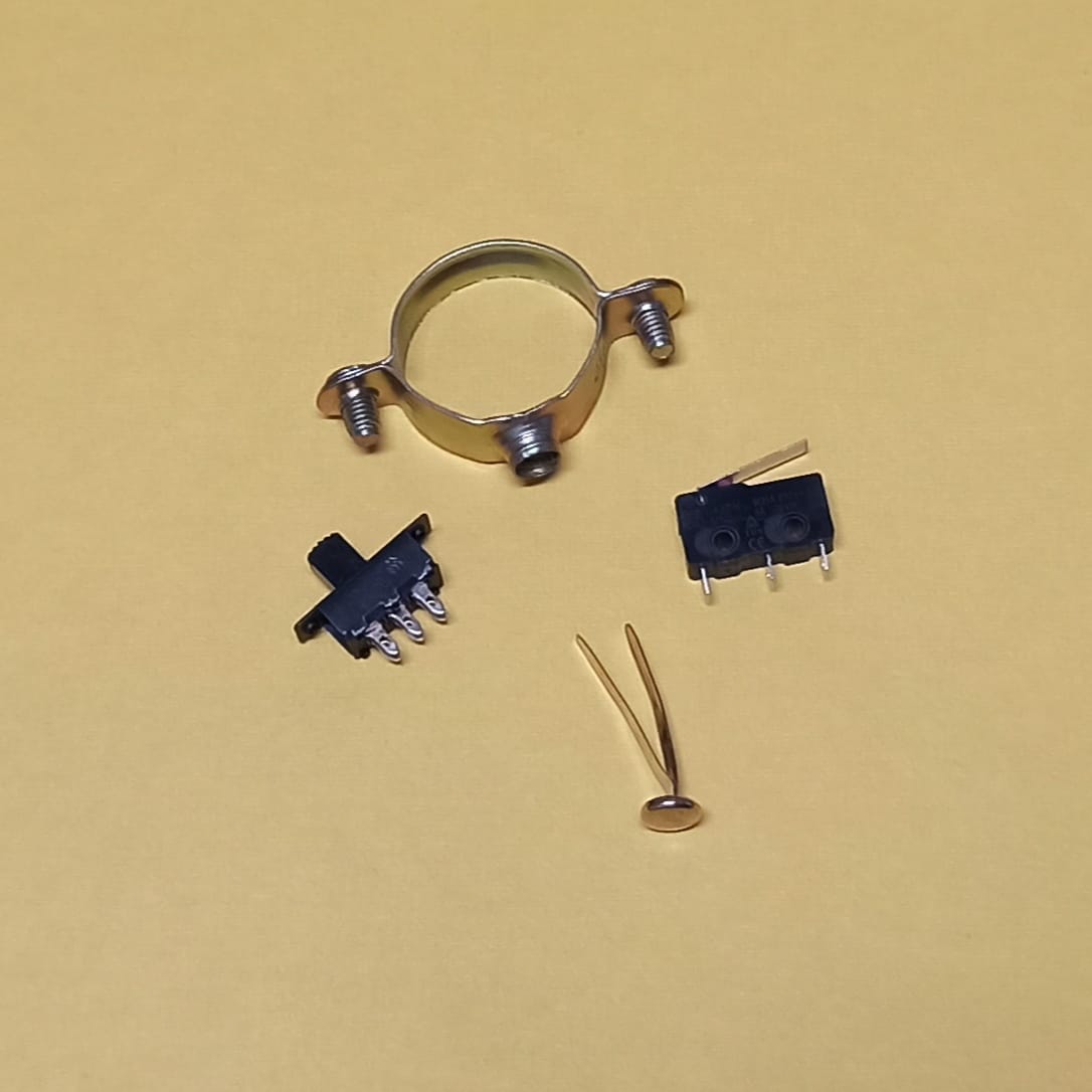 aparece un final de carrera, un encuadernandor una abrazadera de tubos y un conmutador de 6 contactos