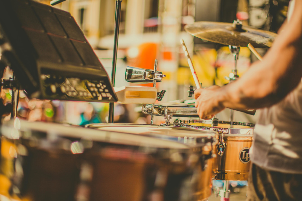 Fotografía de persoa tocando instrumentos de percusión, típicos na batucada.