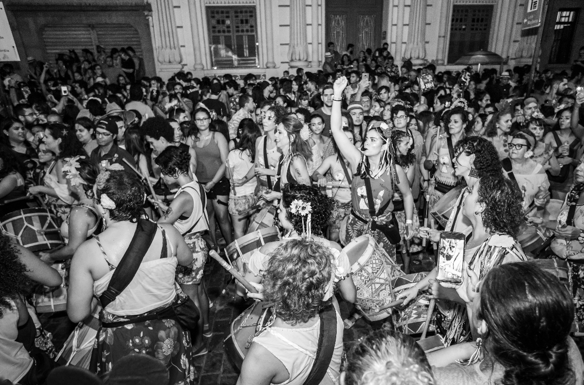 Foto En Escala De Grises De Personas En Un Concierto Fotografía dunha festa onde unha multitude toca e baila.