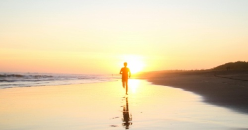 Unha longa viaxe Persoa correndo pola praia no solpor