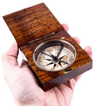 Man esquerda suxeita un compás analóxico que ten un estoxo de madeira.