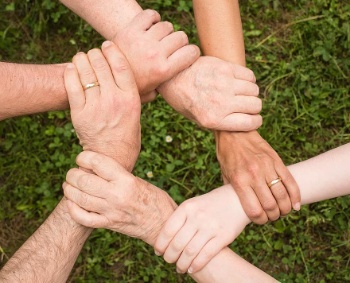 Cooperación Mans collidas entre si representando a cooperación entre persoas