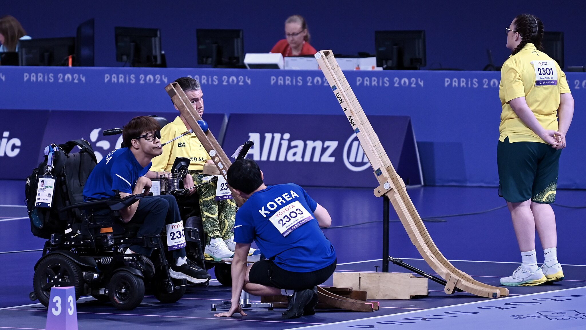 Fotografía dun xogador lanzando a bóla nun partido de boccia con axuda dunha quenlla