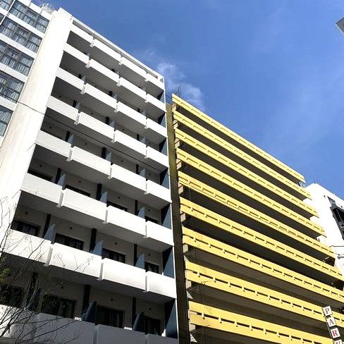 Dos edificios altos con diferentes colores y muchos apartamentos. 