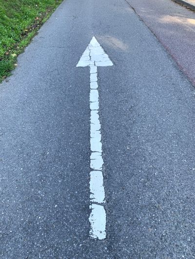 Flecha blanca que marca la dirección en la carretera