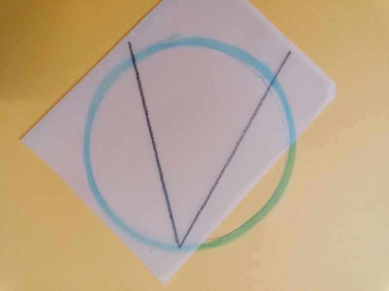 Papel cebolla con ángulo pintado con su vértice sobre un punto de una circunferencia dibujada en un papel