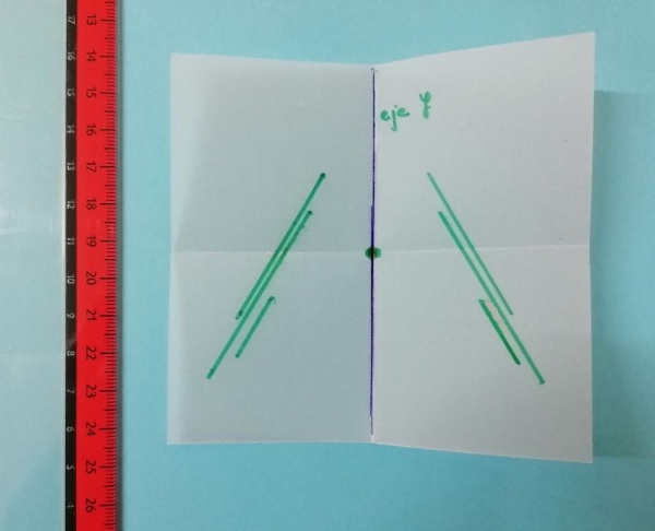 Regla sobre fondo de color con papel vegetal plegado por el medio y varios segmentos