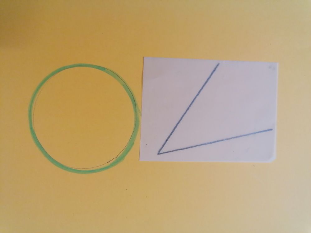 Imagen de una circunferencia dibujada en un papel y un ángulo dibujado en un papel cebolla