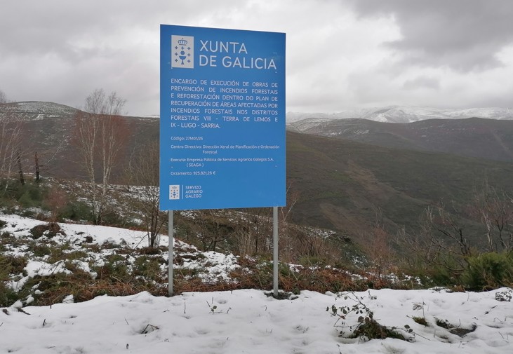 Vista de los montes del Distrito VIII con panel informativo sobre actuación en el monte.