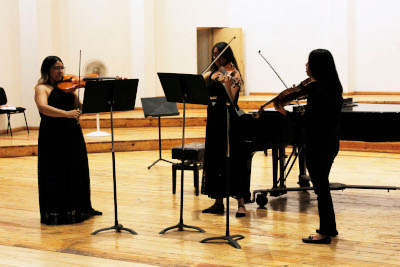 Fotografía de tres persoas tocando instrumentos de corda, violíns e violas